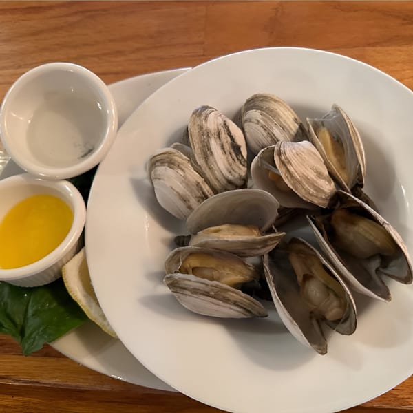 A plate of steamed clams with a side of melted butter and lemon at Windham Restaurant.